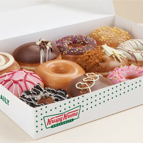 Krispy Kreme staff glazing fresh doughnuts.